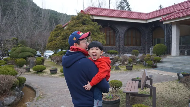 한국인 아버지가 아들을 안고 활짝 웃는 가족의 모습